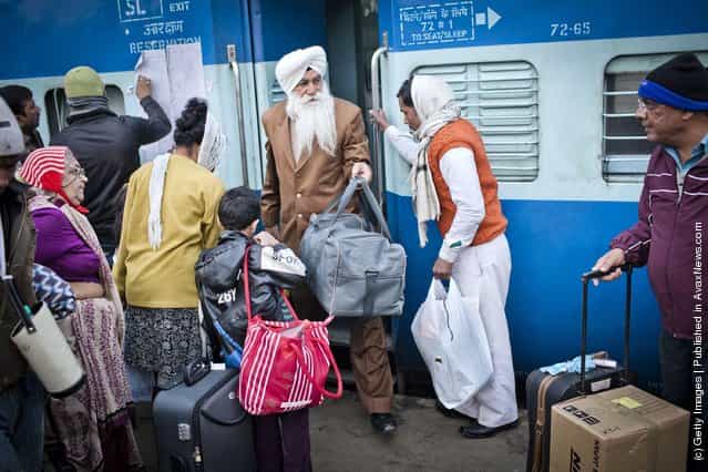 A man alights from a carriage, as others wait to board the Amritsar bound train at the Nizamuddin Railway Station in New Delhi, India