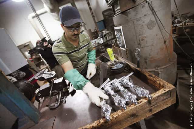 Martin Vega sets an Oscar statuette down to cool off after it was cast at R.S. Owens & Company