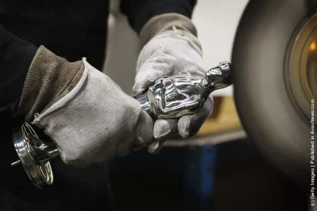 A worker polishes an Oscar statuette at R.S. Owens & Company