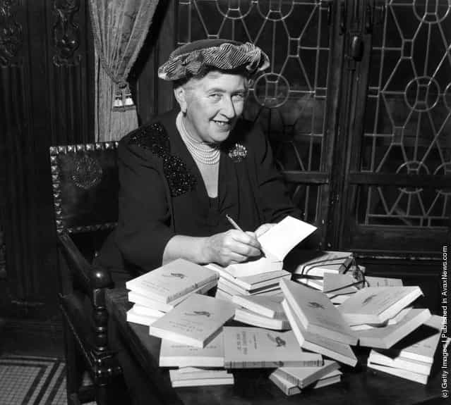 circa 1965: British mystery author Agatha Christie (1890-1976) autographing French editions of her books