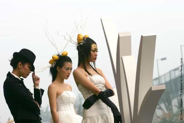 Models promote architectural designs for apartment blocks during the 2007 Xian Autumn Real Estate Trade Fair