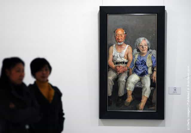Visitors view the work entitled 'Golden Jubilee' by Chinese artist Xin Dongwang at the 'Extension and Integration: A Circuit Exhibition In Hubei Of Study on the Modern Chinese Oil Painting' at the Hubei Museum of Art