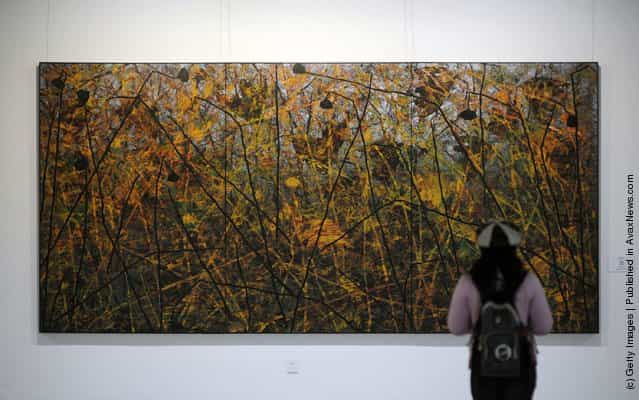 A visitor views the work entitled 'Wild Lotus' by Chinese artist Huang Guanyu
