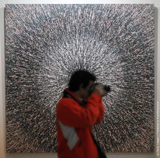 A visitor takes pictures in front of the work entitled 'Universal Speed NO.19' by Chinese artist Meng Luding