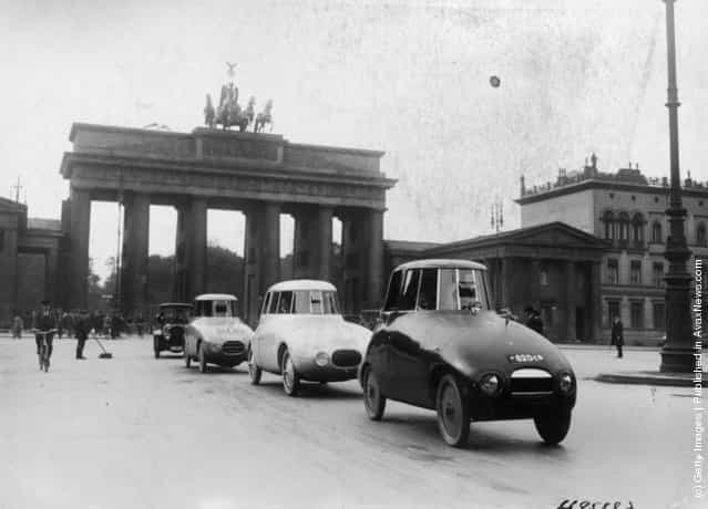 A pioneering experimental streamlined car with bodywork designed by Hungarian-born German aerodynamicist Paul Jaray being driven around the streets of Berlin for the first time, circa 1935. The Brandenburg Gate is in the background
