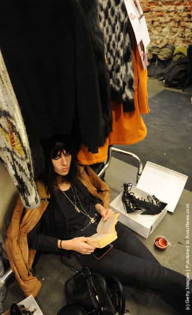 A model reads her book backstage at the Iceberg Autumn/Winter 2012/2013 fashion show as part of Milan Womenswear Fashion Week