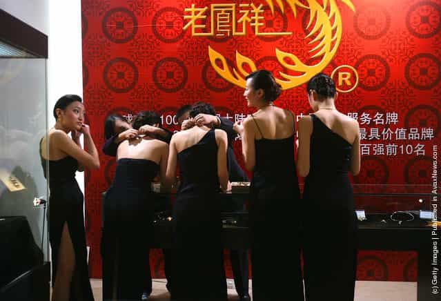 Models wait to promote jewelry during a leading watch and jewelry show at Three Gorges Museum