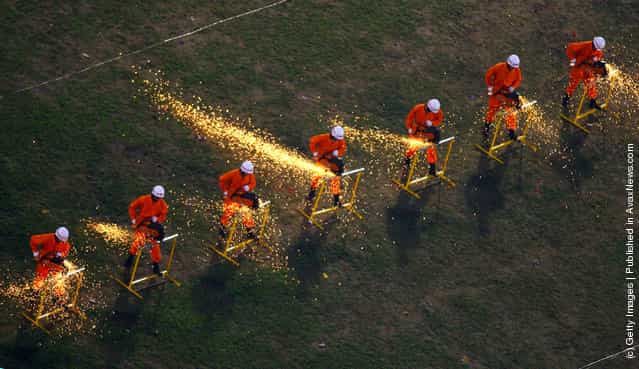 Firemen cut barriers during an anti-terror drill themed To Welcome Olympic Games, To Ensure the Security at Datianwan Stadium in Chongqing Municipality, China