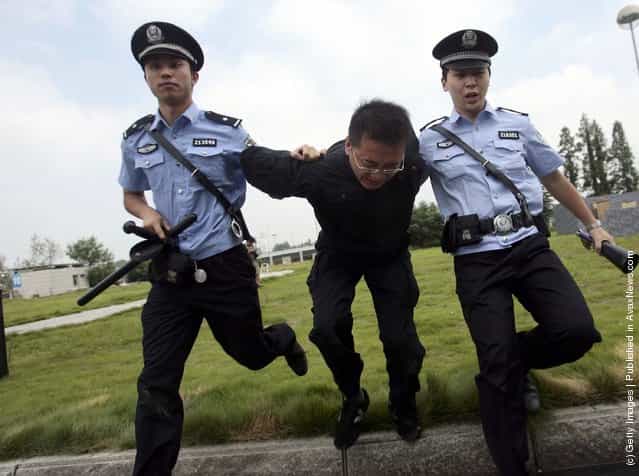 Two policemen escort a simulated suspect during an anti-terror drill