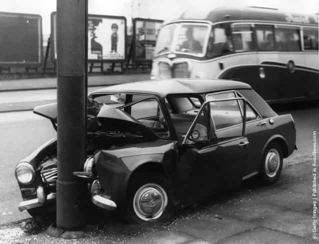 1963: A crashed car by the side of the road in Stratford, east London