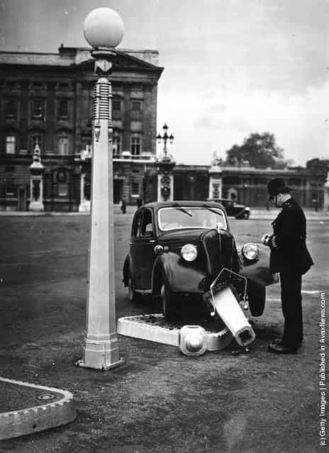 1939: A policeman views a car crashed into a traffic island outside Buckingham Palace