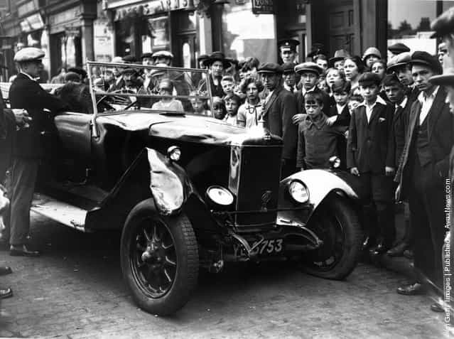 1926: A crowd of spectators in Stepney Green, east London, with one of the two cars which were involved in a crash there, killing two men and injuring a third