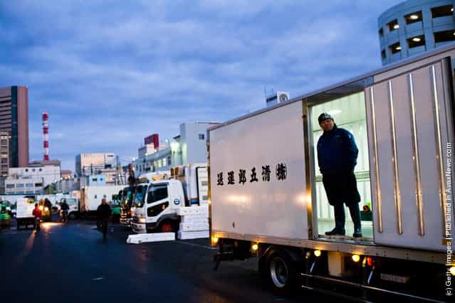 A worker waits for goods to be packed into a truck at the Tsukiji fish market