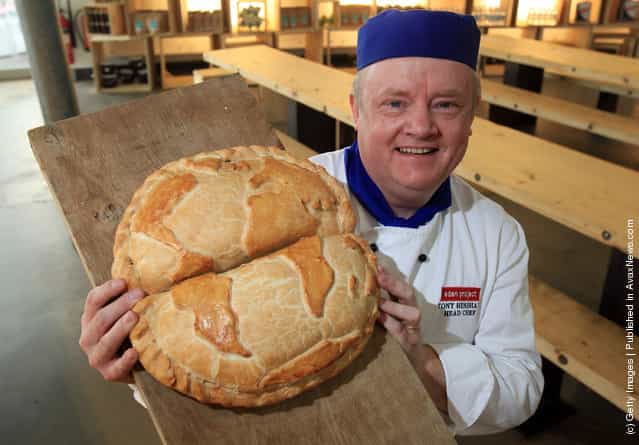 Head chef Tony Henshaw poses for a photograph with a giant pasty shaped as the globe at the World Cornish Pasty Championships at The Eden Project