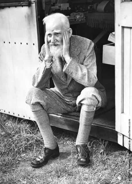 Irish playwright George Bernard Shaw (1856 - 1950) sits in the doorway of the garden shed at his home in Ayot St Lawrence, Hertfordshire, where he does most of his writing, July 1946