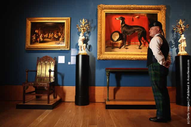 A member of staff at the Queens Gallery views a painting in the Royal Collection
