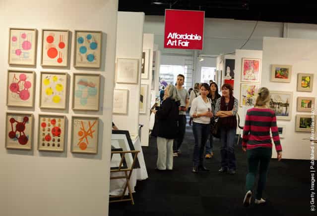 Visitors to The Affordable Art Fair look at paintings