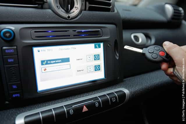 A car2go empoloyee demonstrates how the cars key is stored in the dashboard