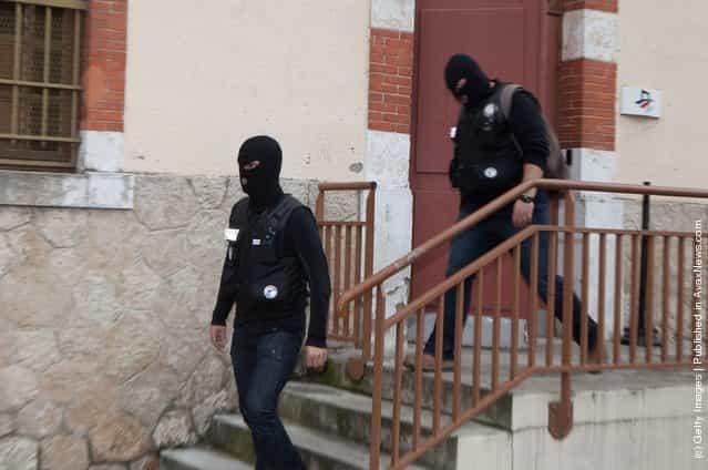 Masked officers stand by as police continue to surround a property during an operation to arrest 24-year-old Mohammed Merah, the man suspected of killing seven victims including three children in separate gun attacks