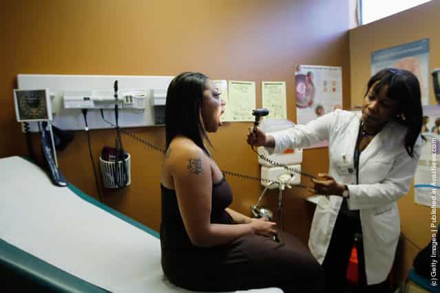 Marche Curry (L), who is a college student and unable to afford insurance, is examined by Dr. Nadine Altidor during a routine checkup at the Jessie Trice Center for Community Health clinic