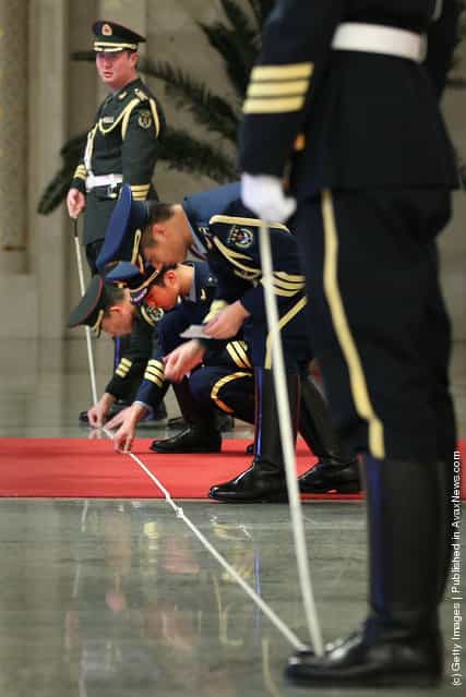 Members of an honour guard use tape measures on the floor to line up as they prepare for a welcoming ceremony for Indonesia's President Susilo Bambang Yudhoyono inside the Great Hall of the People on March 23, 2012 in Beijing, China