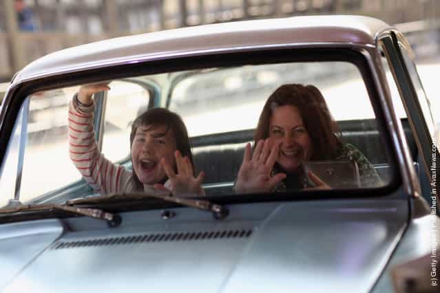 A woman and her daughter have their picture taken inside the Ford Anglia that was used in Harry Potter and the Chamber of Secrets (the second film in the series) at the new Harry Potter Studio Tour at Warner Brothers Leavesden Studios
