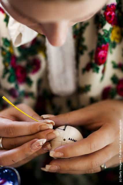 Melanie Baier from the village Obergurig wearing a traditional Lusatian sorbian folk dress, paints an Easter egg in traditional Sorbian motives at the annual Easter egg market