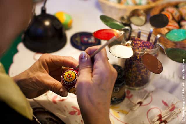 Sigrid Bolduan from the village Klein Loitz, wearing a traditional Lusatian sorbian folk dress, paints an Easter egg in traditional Sorbian motives at the annual Easter egg market