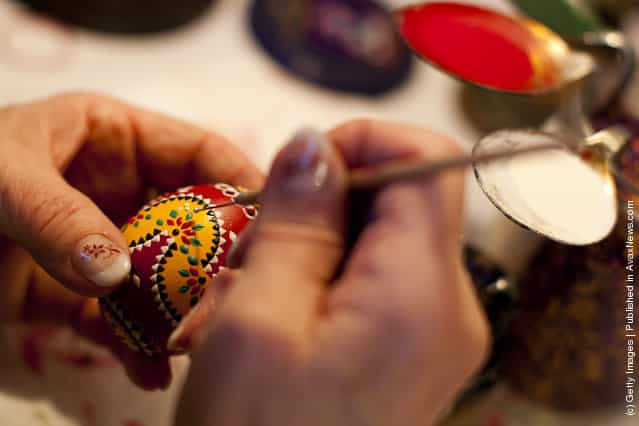 A woman, paints an traditional Lusatian sorbian folk Easter egg in traditional Sorbian motives at the annual Easter egg market