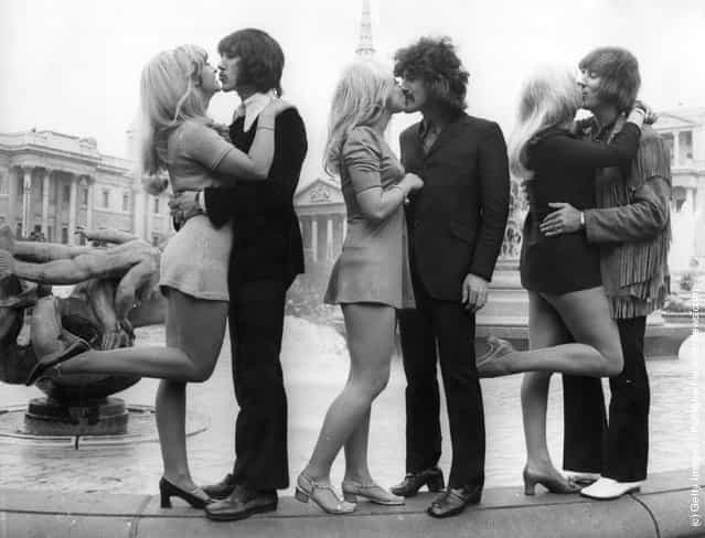 Three members of English pop group The Tremeloes; Chip Hawkes, Alan Blakley and Dave Munden, kissing their brides; Carol Dilworth, Lyn Stevens and Andree Wittenberg, in Trafalgar Square, London, 1967