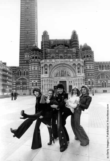 1976: Pop singer Alvin Stardust, centre, with members of the singing dance troupe Guys And Dolls outside Westminster Cathedral, London, where they have been rehearsing for a concert