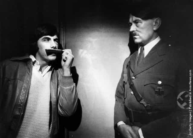 1980: A visitor to Madame Tussauds tries the effect of a pocket comb to mimic Adolf Hitlers moustache
