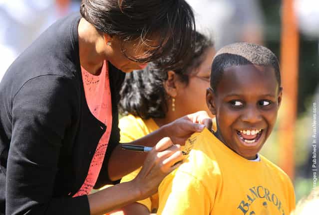 First lady Michelle Obama signs autograph on the T-shirt of Dylan Molineaux, a 4th grader of Bancroft Elementary School in DC, during the fourth annual Kitchen Garden spring planting