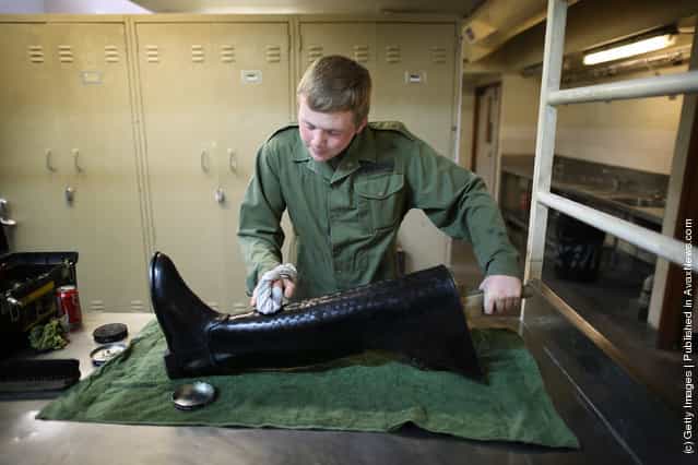 Trooper Aaron Wilson of The Household Cavalry Mounted Regiment (HCMR) polishes one of his riding boots at Hyde Park Barracks