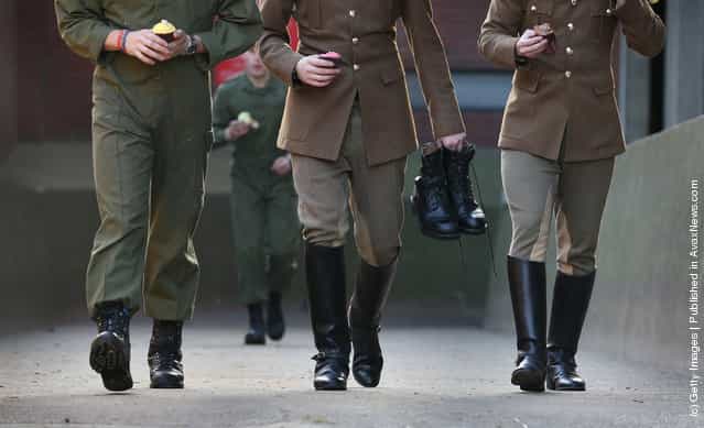 Members of The Household Cavalry Mounted Regiment (HCMR) carry cupcakes for breakfast and a pair of boots before parade at Hyde Park Barracks