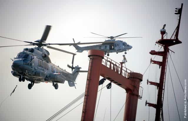 AS332 [Super Puma] helicopters fly over the TK Bremen cargo ship on Kerminihy beach in Erdeven, on December 16, 2011
