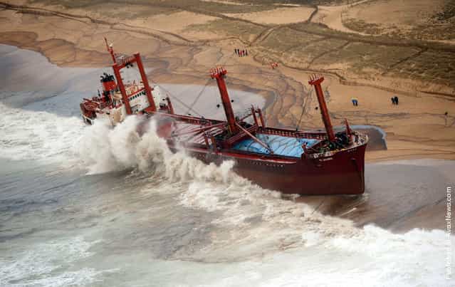 In this image made available by Frances Marine Nationale, the cargo ship TK Bremen sits stranded on a beach near Erdeven, France, on December 16, 2011, spilled fuel oil fouling the water