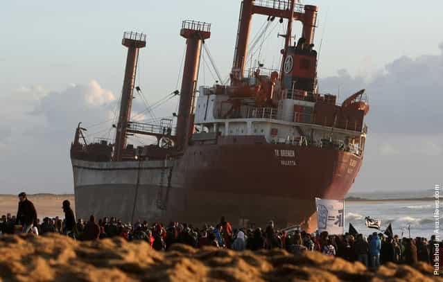 Demonstrators and onlookers gather in front of the beached cargo TK Bremen at Erdeven, on December 17, 2011