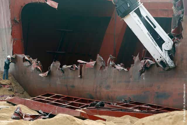 A closer view of the hydraulic shear cutting apart the hull and dismantling the TK Bremen on Kerminihy beach, on January 7, 2012