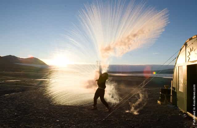 Long Term Ecological Research (LTER) field team member Anna Bramucci throws hot water into the air to watch it turn to ice crystals and vapor on a -25 F (-32 C) day at Lake Fryxell field camp in Taylor Valley, Victoria Land on March 30, 2008