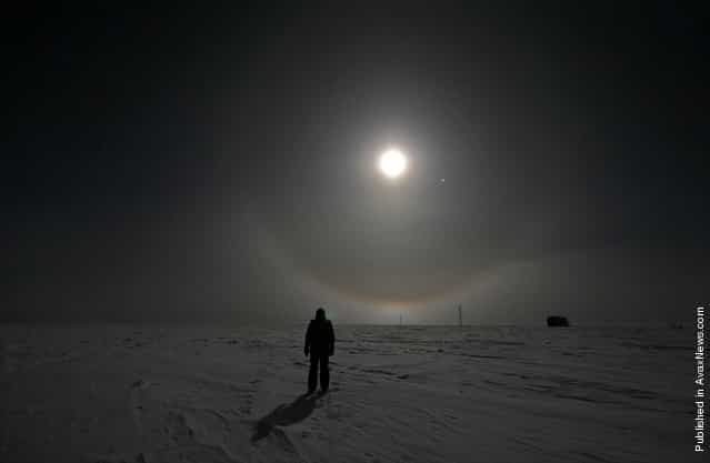 A US Antarctic Program participant enjoys a walk under a full moon at Amundsen-Scott South Pole Station on June 19, 2008