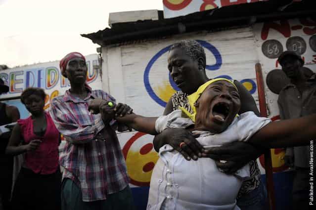 Armante Cherisma cries in front of the body of her daughter, Fabienne, 15 years old, killed by a policeman during lootings in the Marthely Seiee street January 19, 2010 in Port-au-Prince