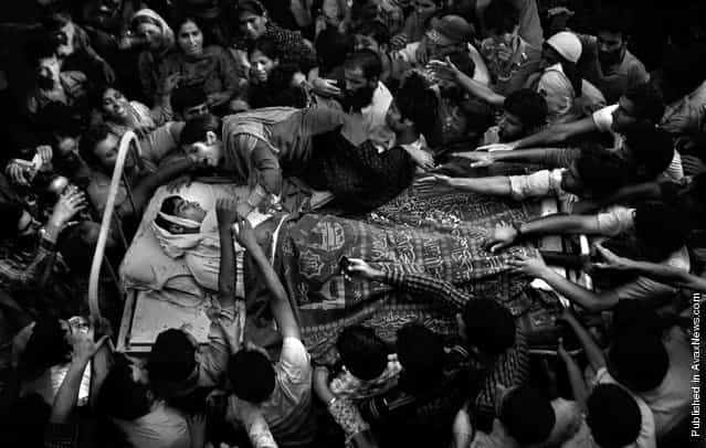 In this Sept. 6, 2010 file photo, a sister of Feroz Ahmad, alias Showkat, who was killed by forces, wails as she clings to the bed carrying the body of her brother during his funeral in Pattan, some 35 kilometers (22 miles) north of Srinagar, India. Associated Press photographer Altaf Qadri was awarded the 1st prize in the the People in the News singles category at the 2011 World Press Photo awards