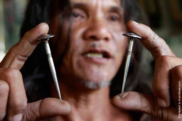 Penitent Ruben Eniaje holds up two of the custom-made three-inch stainless steel nails that will be used for his crucifixion on Good Friday in Cutud, San Fernando Pampanga, in northern Philippines on April 21, 2011. Dozens of penitents were crucified on wooden crosses on Good Friday as part of their annual reenactment of the crucifixion of Jesus Christ