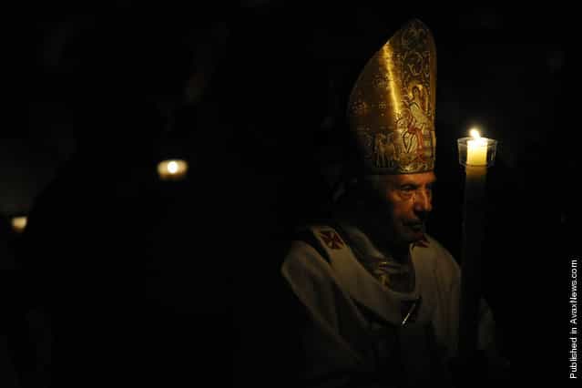 Pope Benedict XVI holds a candle during the Easter Vigil Papal mass on Holy Saturday on April 23, 2011, at St Peter's Basilica at The Vatican