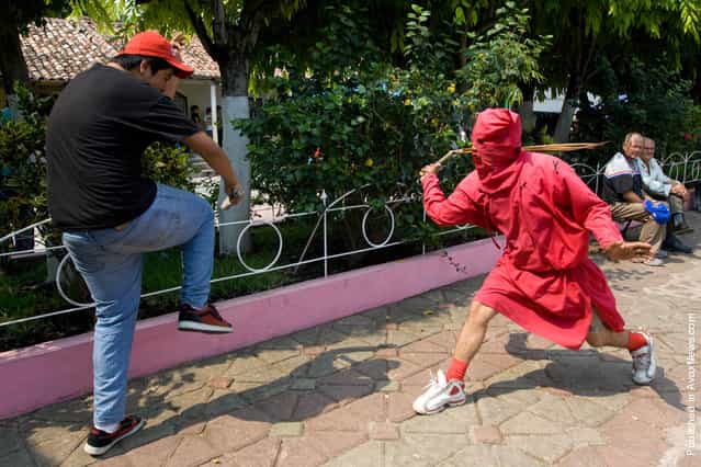 An actor dressed as a demon whips a resident during a ceremony as part of religious activities to mark the start of Holy Week in Texistepeque, Santa Ana, El Salvador on April 18, 2011. Participants receive lashes from the actors, also know as Talciguines, as punishment for their sins