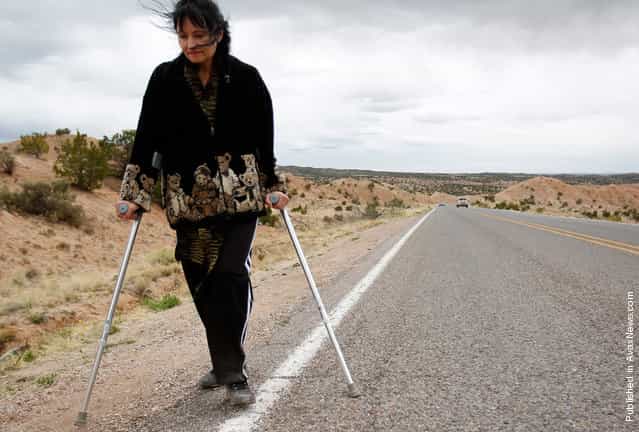Bernadette Saavedre walks along the side of the road as she makes her pilgrimage to El Santuario de Chimayo in Chimayo, New Mexico April 23, 2011. Thousands of people walk to the little chapel over Easter weekend, where they believe the dirt inside holds the power to heal, some from as far away as Mexico and Colorado