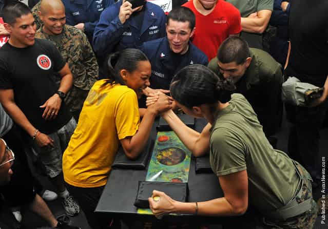 Seaman Denise Williams and Marine Sgt. Amanda Joseph, participate in an arm wrestling competition aboard the amphibious assault ship USS Makin Island (LHD 8)