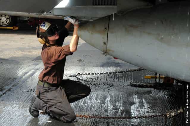 Aviation Structural Mechanic Airman Ashley Botbyl, from Warwick, N.Y., scrubs down an F/A-18C Hornet assigned to the Blue Diamonds of Strike Fighter Squadron (VFA) 146 aboard the aircraft carrier USS Ronald Reagan (CVN 76)