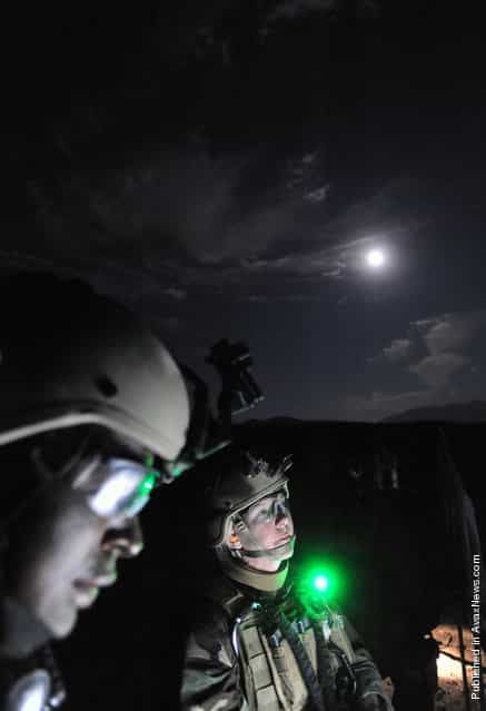 Mass Communication Specialist 1st Class Denise Martin, right, assigned to Fleet Combat Camera Group Pacific, inspects a target during a night weapons shoot as part of the Fleet Combat Camera Group Pacific Summer Quick Shot 2011